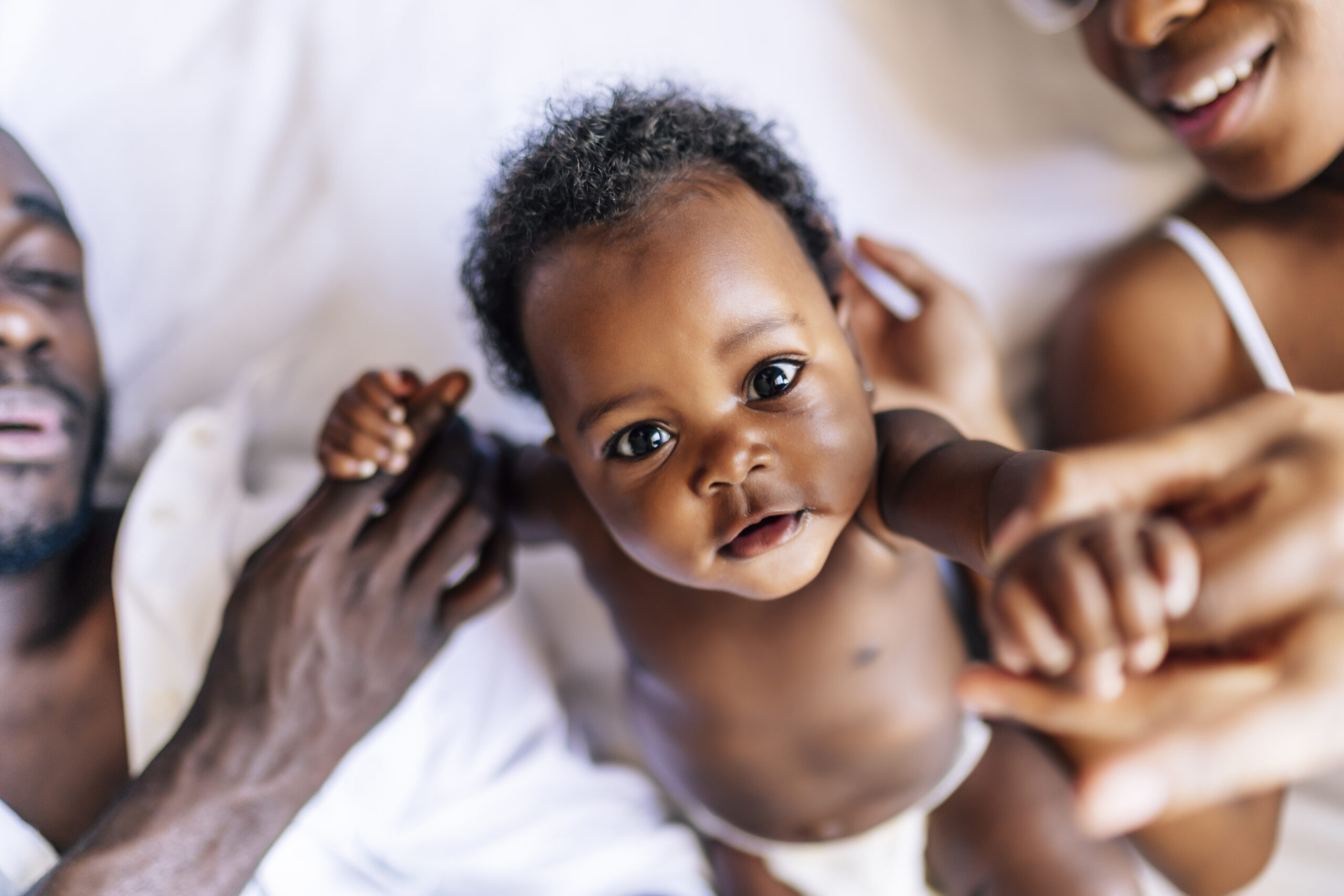A cheerful family of African-Americans with a mother, father and baby having fun together
